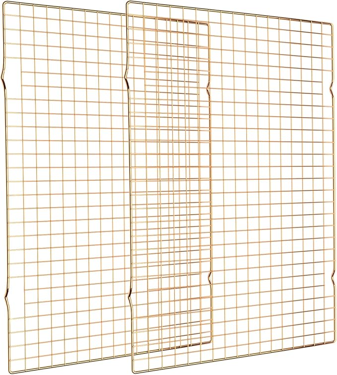 two gold stainless steel wire cooling racks stacked together on a white background