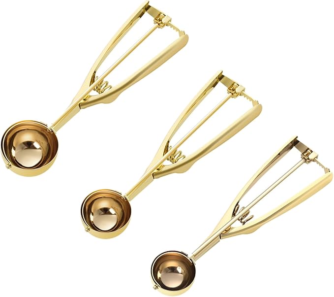 three gold stainless steel cookie scoops in small, medium, and large sizes on white background