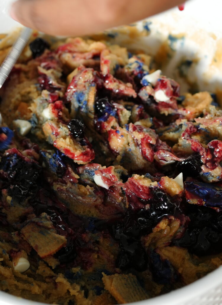 Cookie dough with blueberry jam and Oreo chunks in a mixing bowl.
