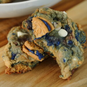 Close-up of white chocolate chip blueberry pie cookies loaded with blueberry jam swirls and Oreo cookie pieces in a bowl.