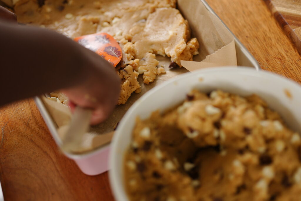 Cookie dough pressed evenly into a parchment-lined 13x9 pan.