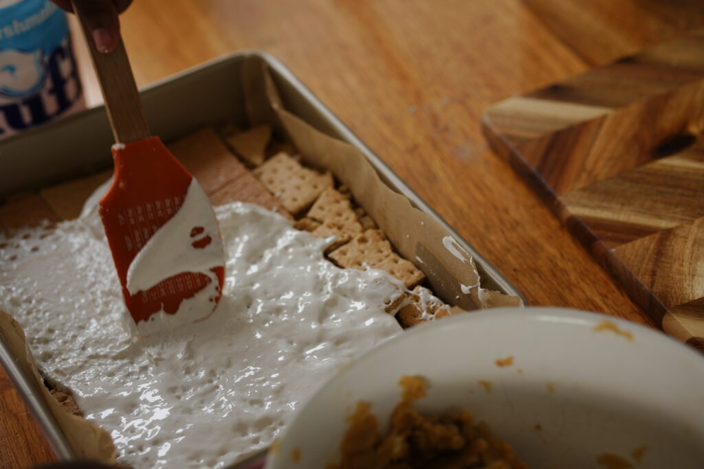 Marshmallow fluff spread evenly over graham crackers in baking pan.