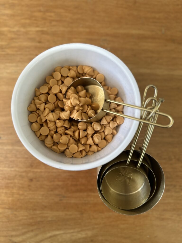 Butterscotch chips in a bowl with measuring cups – prepped for butterscotch banana bread batter