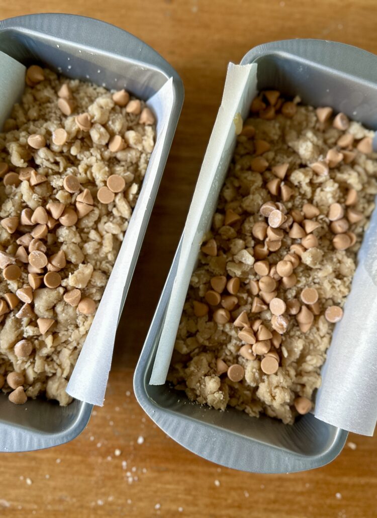 Transferring butterscotch banana bread batter into a prepared loaf pan, smoothing the top for even baking