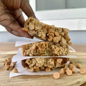 Three thick slices of butterscotch banana bread stacked, with a hand lifting the top slice for a closer look