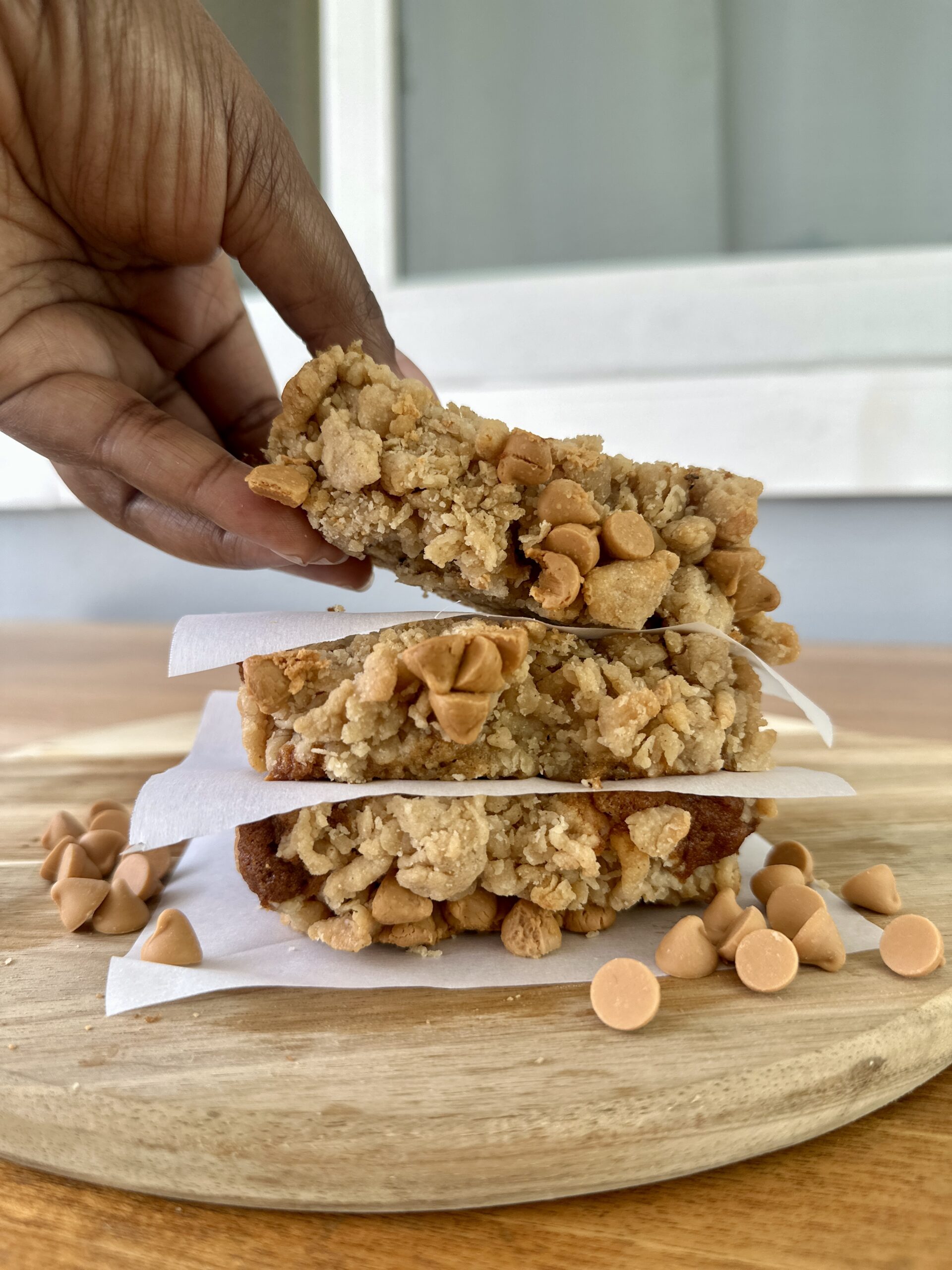 Three thick slices of butterscotch banana bread stacked, with a hand lifting the top slice for a closer look