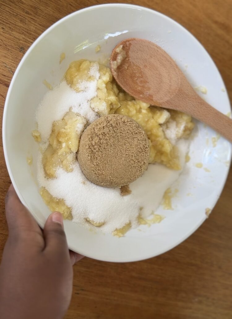 Combining melted butter, sugars, eggs, and vanilla with mashed bananas for butterscotch banana bread batter