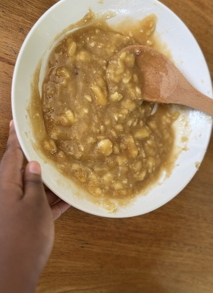Combining melted butter, sugars, eggs, and vanilla with mashed bananas for butterscotch banana bread batter