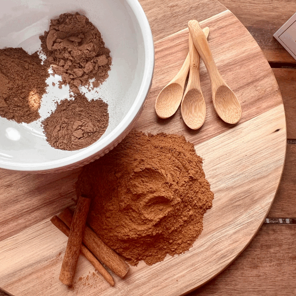 Ingredients for homemade pumpkin pie spice separated on a cutting board – ground cinnamon, nutmeg, allspice, and cloves ready for mixing