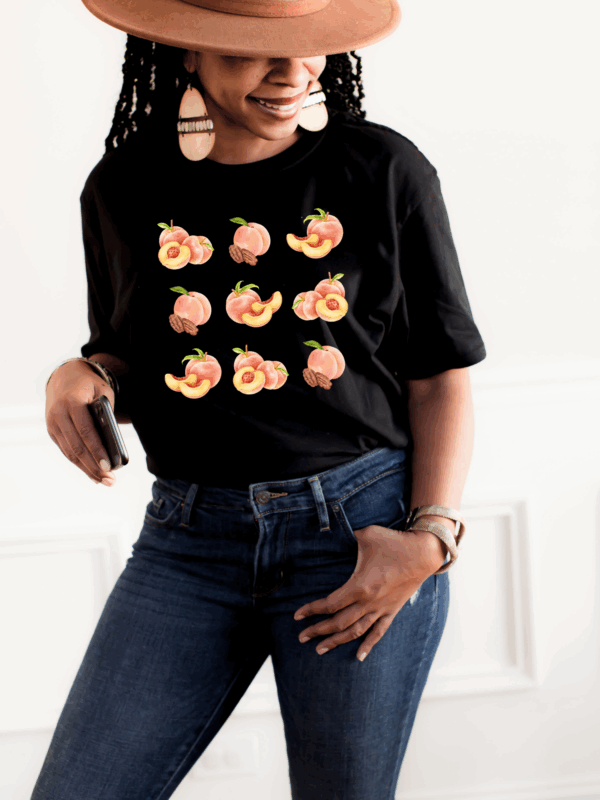 Woman smiling in black Peachy Vibes graphic tee with watercolor peach design.