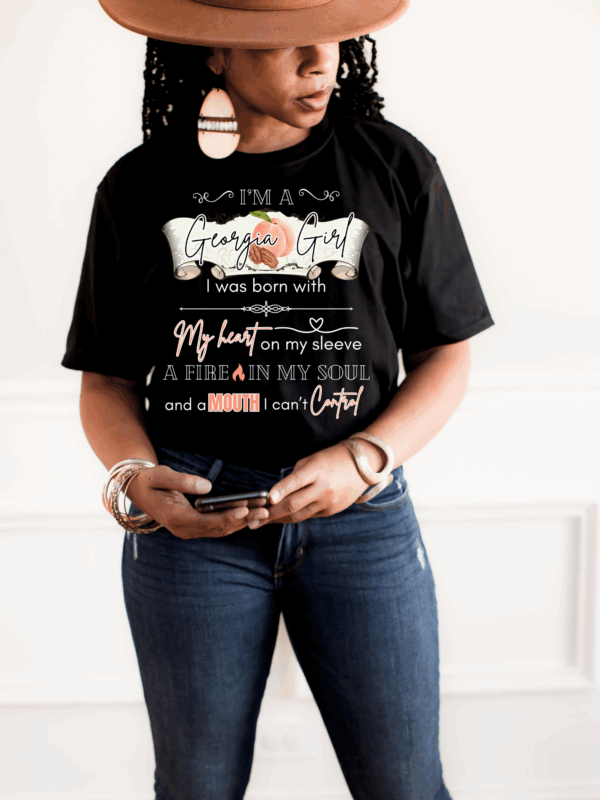 Woman in Georgia Girl Graphic Tee holding phone and wearing bangles.