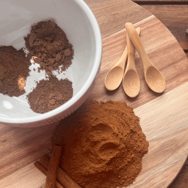 Ingredients for homemade pumpkin pie spice separated on a cutting board – ground cinnamon, nutmeg, allspice, and cloves ready for mixing