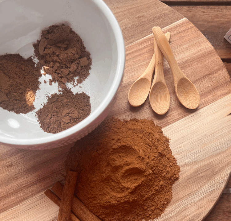 Ingredients for homemade pumpkin pie spice separated on a cutting board – ground cinnamon, nutmeg, allspice, and cloves ready for mixing