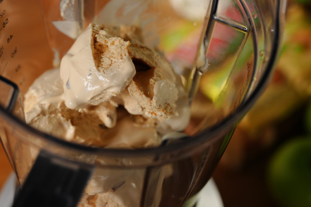 Sea salt caramel ice cream inside a blender, ready to be mixed with chilled apple pie filling to create a smooth and creamy caramel apple milkshake.